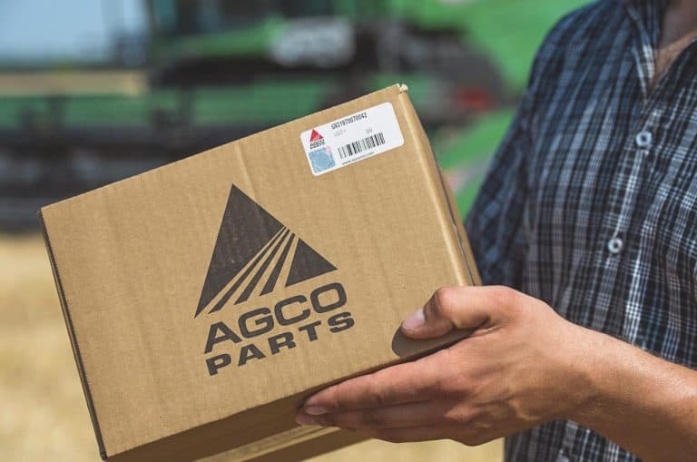 An AGCO Parts box held beside agricultural machinery
